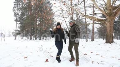 一个年轻人和一个穿着温暖冬天衣服的女孩，在一个下雪的冬天公园里享受彼此的存在